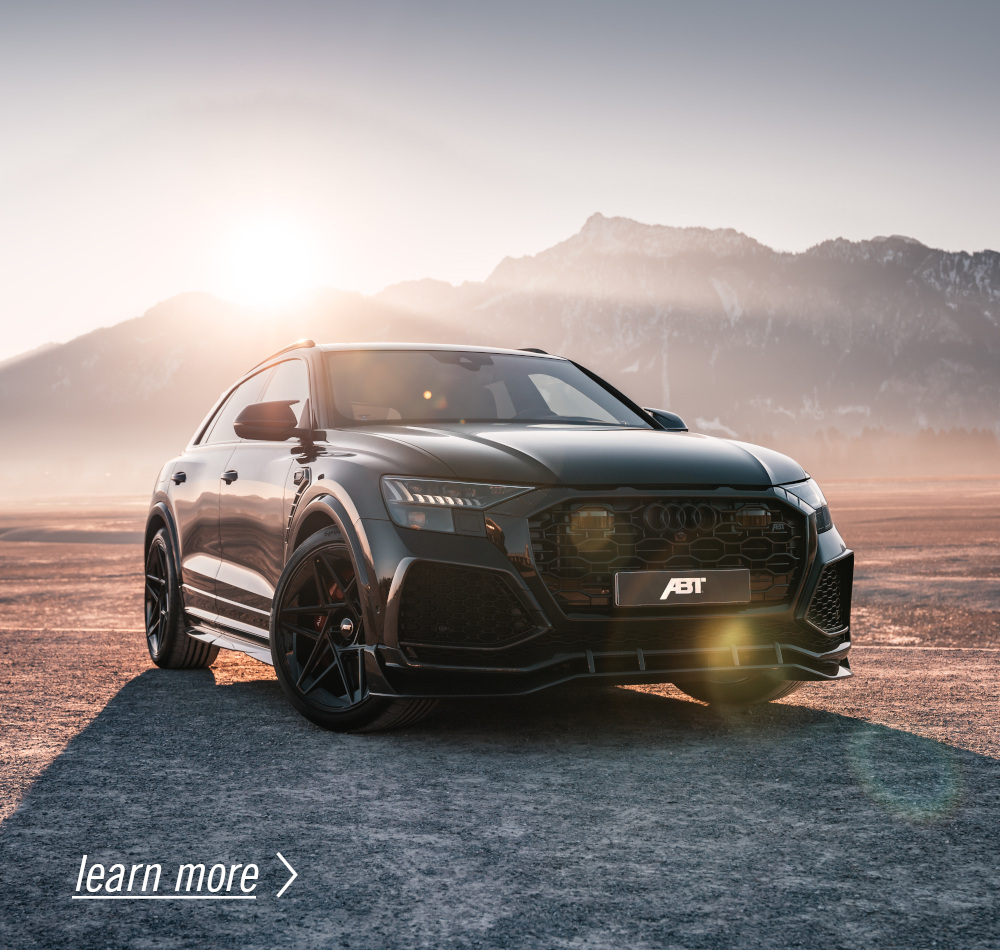 Black RSQ8 from the side front view at sunrise in front of a mountain panorama